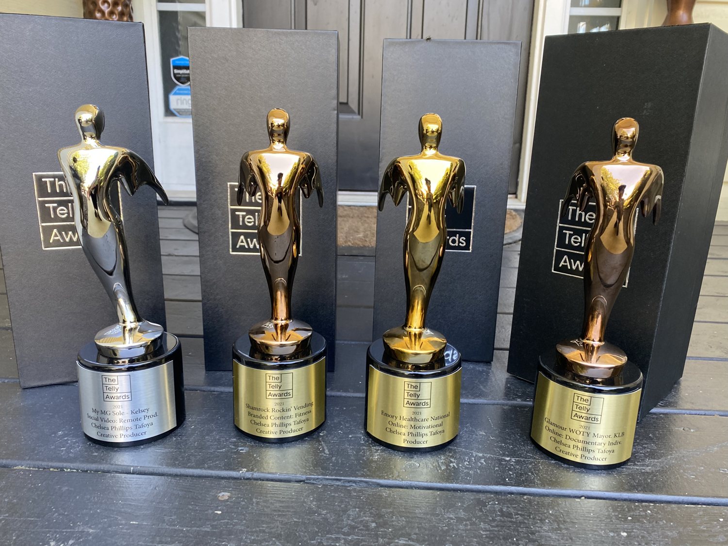 Four of Chelsea's Telly Award statuettes lined up